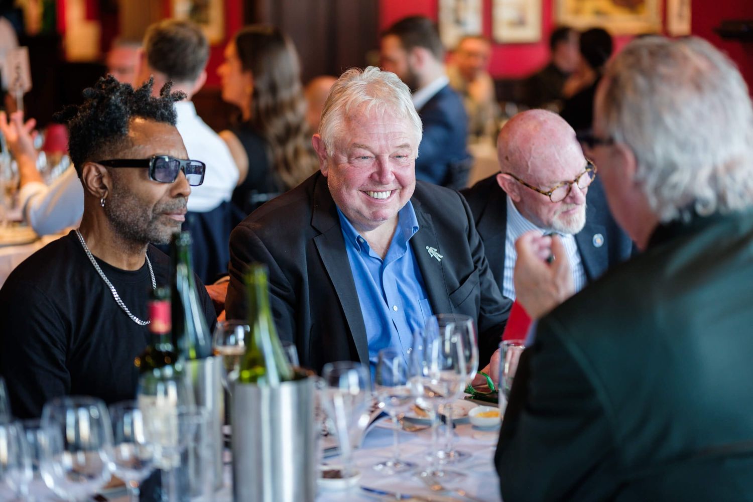 People gathered around a table enjoying wine tasting and conversation in a social setting.