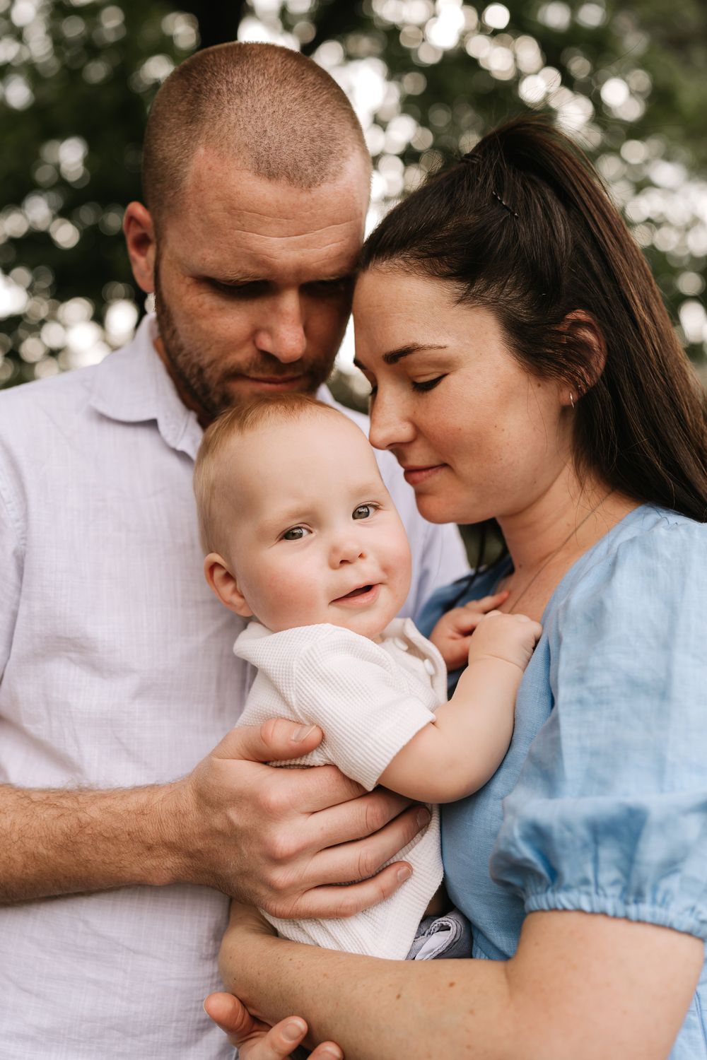 A father, mother and young child in soft golden light during an outdoors Perth family photography session