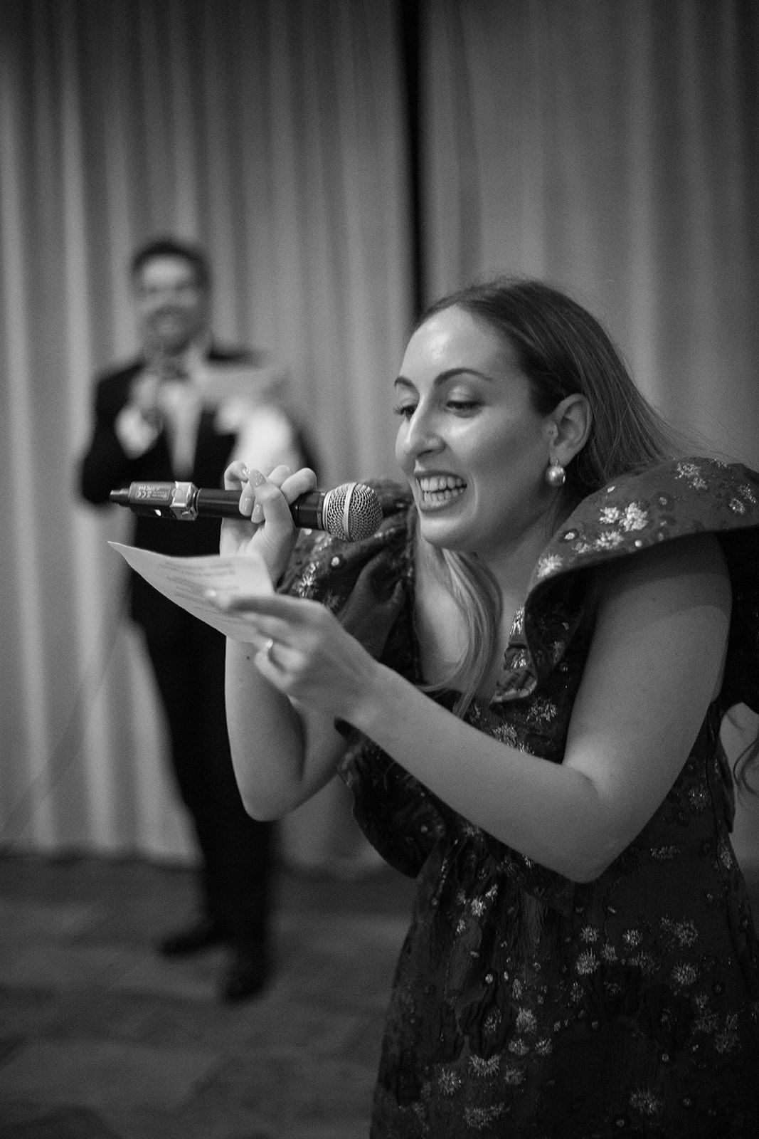 A sequence of black and white photos showing a person in a floral dress singing into a microphone on stage.