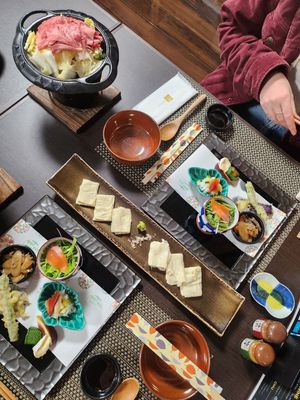 Overhead view of Japanese restaurant table settings with multiple dishes and plates arranged in a row.
