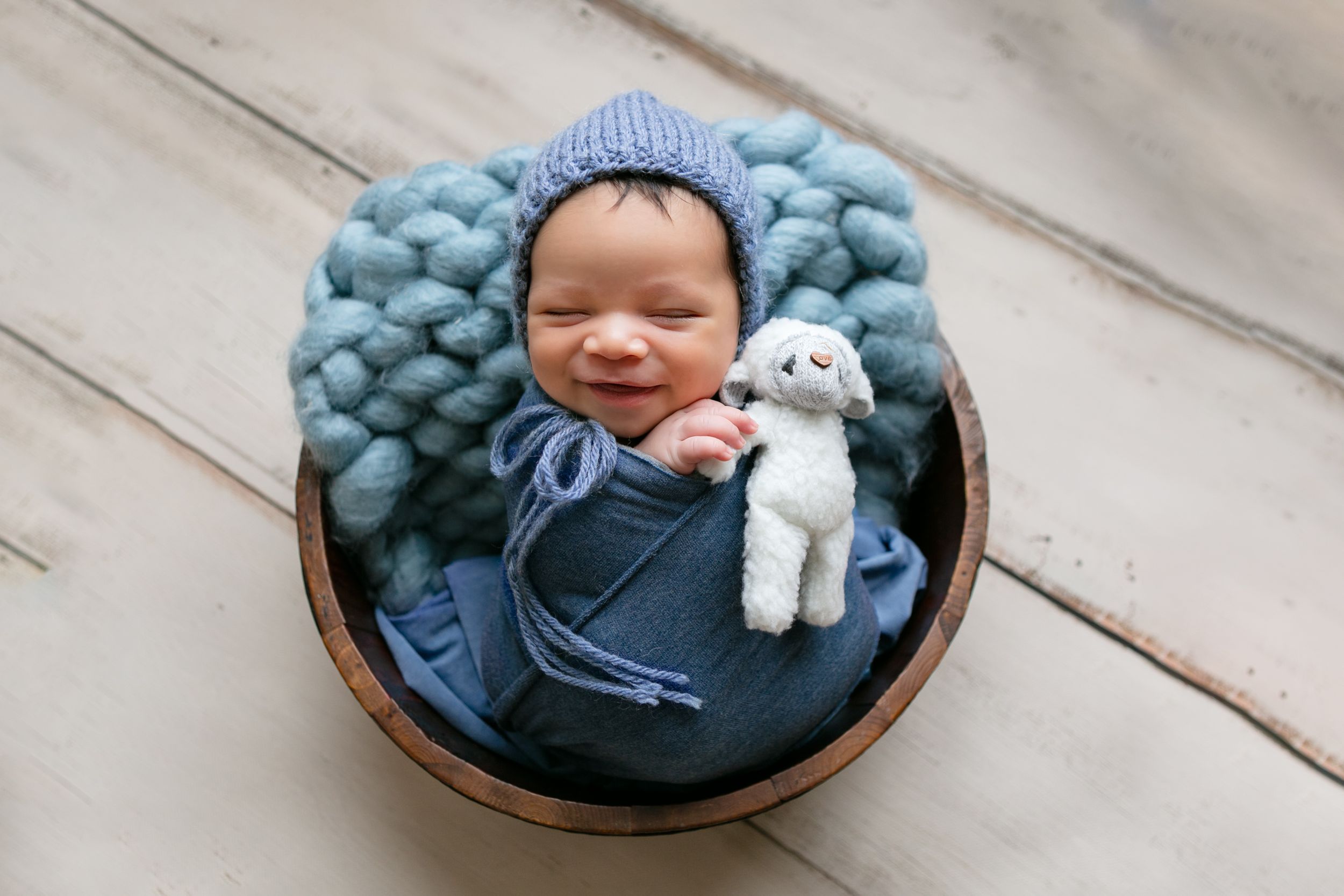 Orlando Newborn Photography, Sanford Newborn Photography, Newborn baby posed with a stuffed animal, smiling, dressed in blue