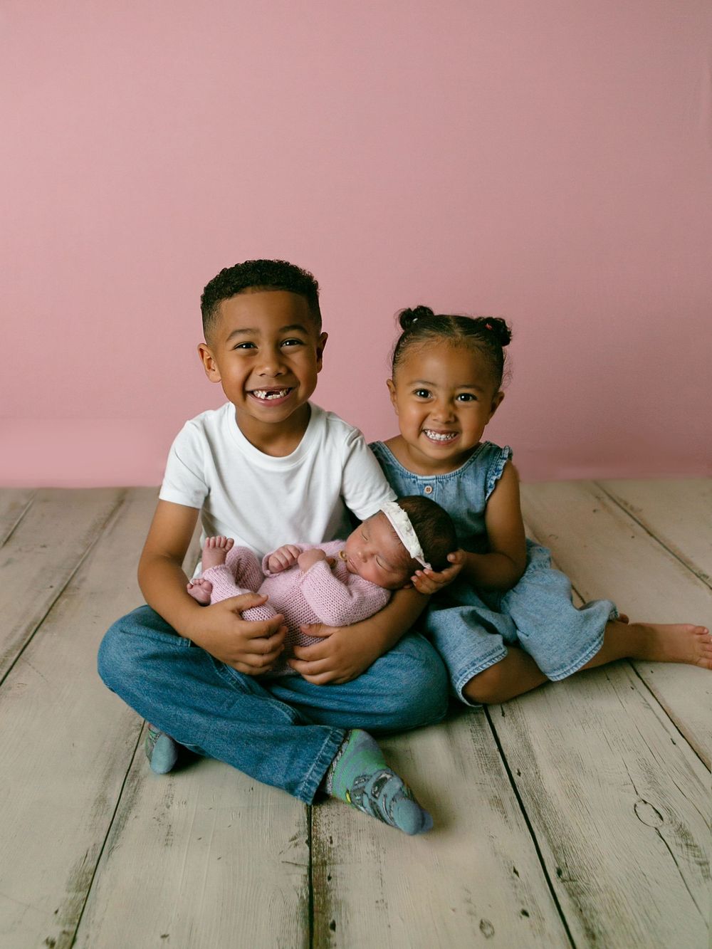 Two smiling children holding newborn sibling, Orlando Newborn Photography, Sanford Newborn Photography, Orlando Newborn Photos