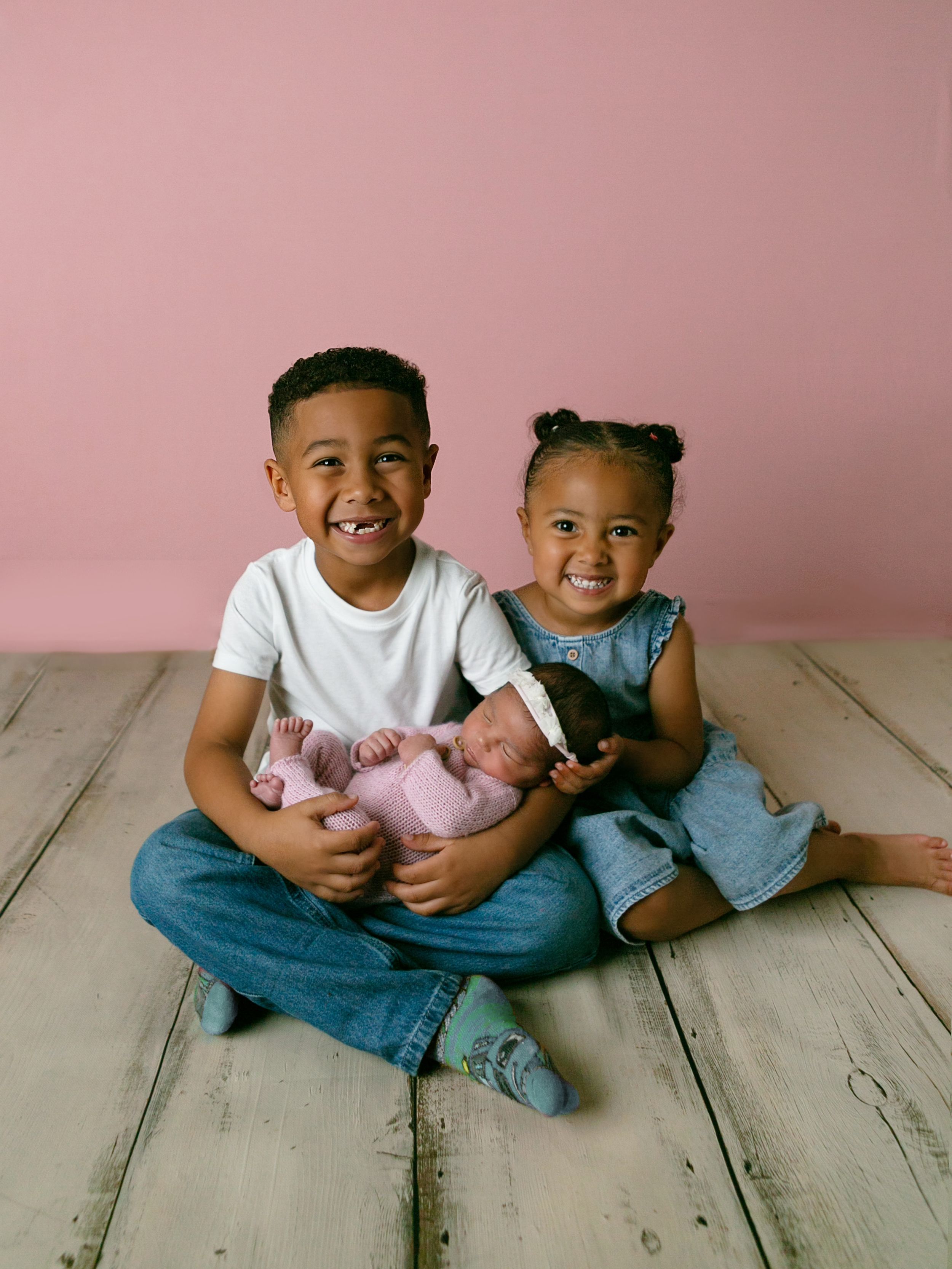 Two smiling children holding newborn sibling, Orlando Newborn Photography, Sanford Newborn Photography, Orlando Newborn Photos
