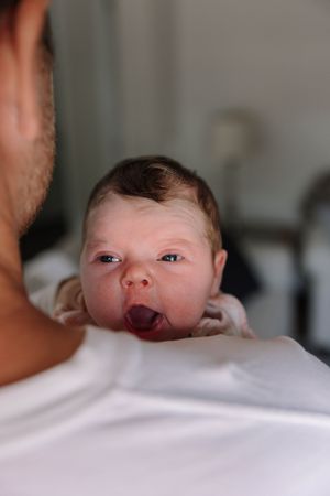 Close-up portrait sequence of alert newborn baby against white background.