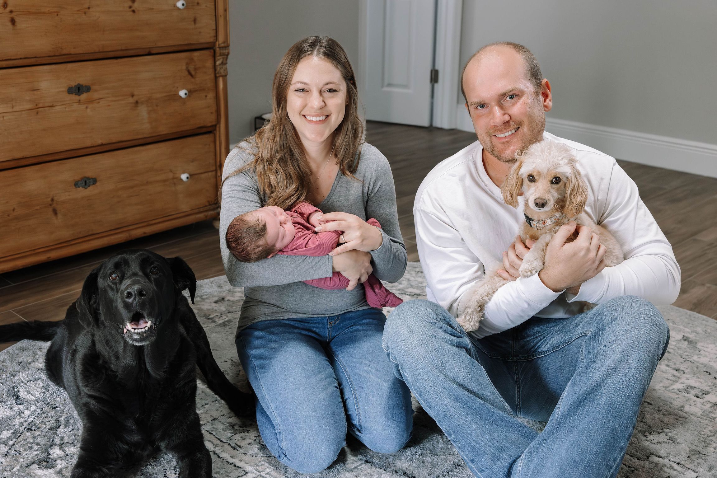 Family photo session showing pets and casual indoor moments on wooden floor.