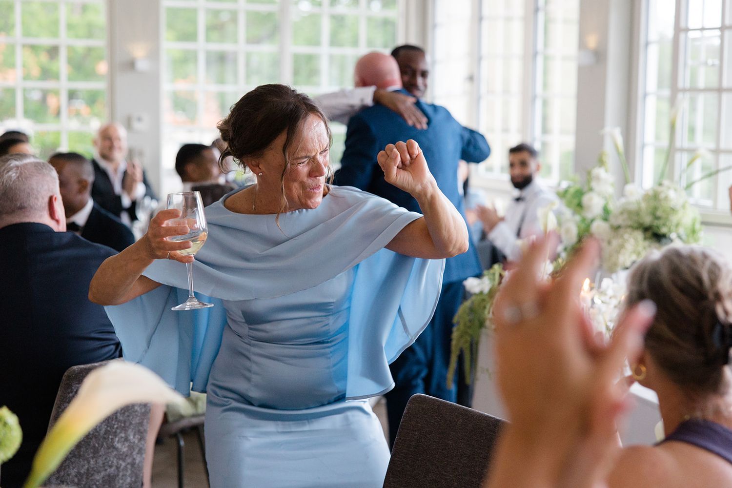 A sequence of black and white photos showing people dancing and moving energetically in a bright studio space.