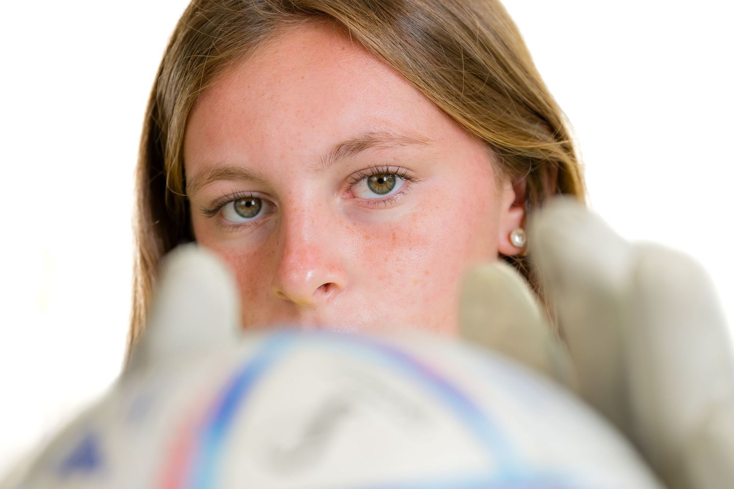 Medical professionals in protective gear and face masks work together in a clinical setting.