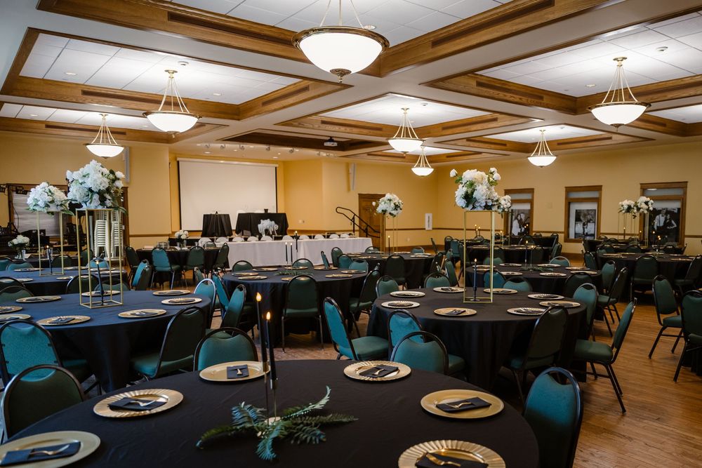 Elegant banquet hall with coffered ceiling, pendant lighting and turquoise chairs set for formal dining.