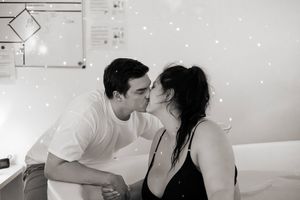 Förlossningsfotografering på Akademiska sjukhuset i Uppsala. Kvinnan är i badkaret och paret kysser varandra
