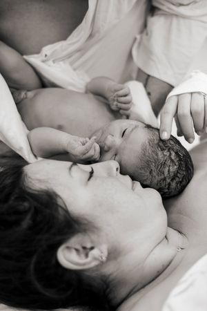 Förlossningsfotografering på Akademiska sjukhuset i Uppsala. Kejsarsnitt, bild på första mötet mellan mamma och bebis