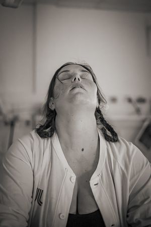 Förlossningsfotografering Södertälje BB. Kvinna lutar huvudet bakåt i en värkpaus.
