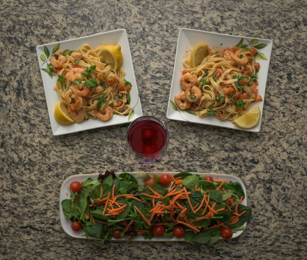A progression of plating a colorful salad with mixed greens, carrots, and garnishes on a granite countertop.