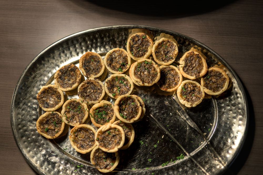 Dried orange slices arranged on a dark textured plate creating an elegant display pattern.