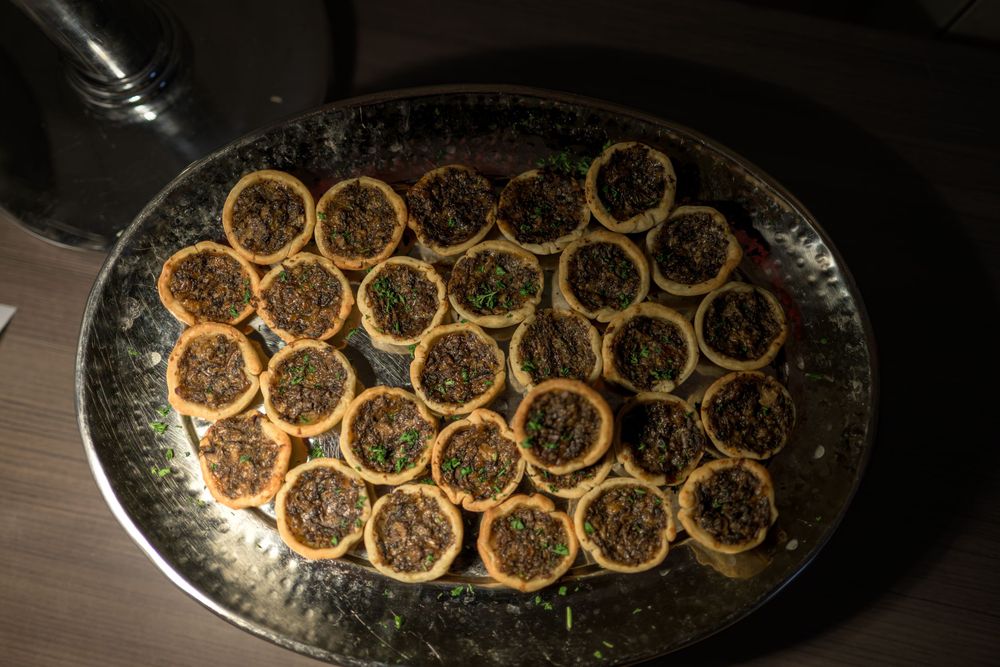 Sliced oranges arranged in concentric circles on a dark platter create an elegant citrus display.