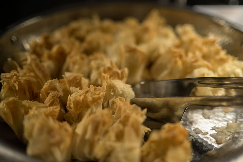 A series of photos showing the preparation of creamy macaroni and cheese in a baking dish.