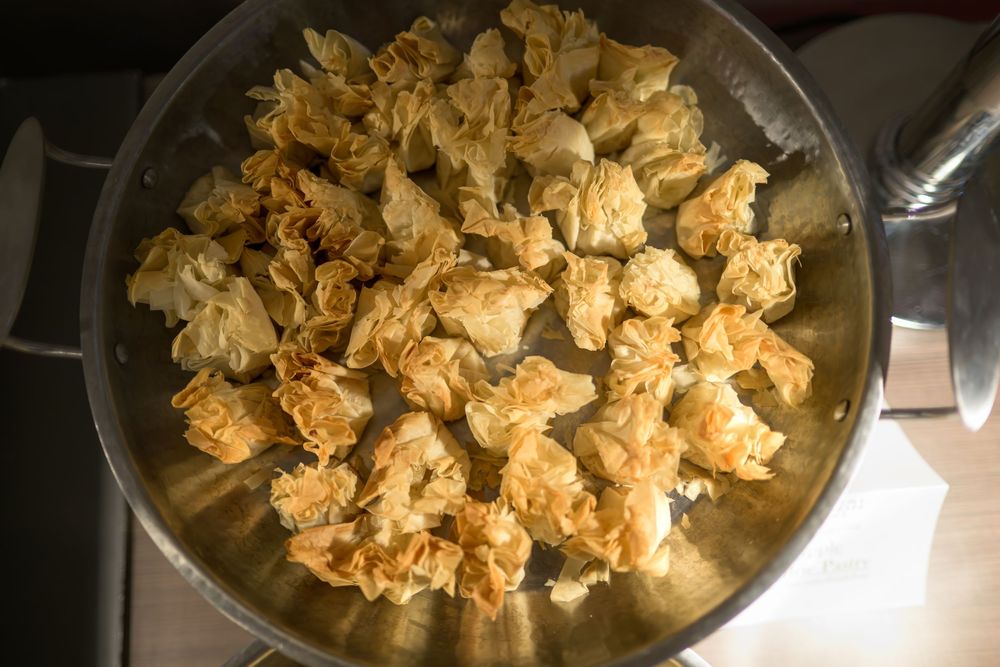 Golden brown chunks of bread or croutons scattered across a dark cooking surface.