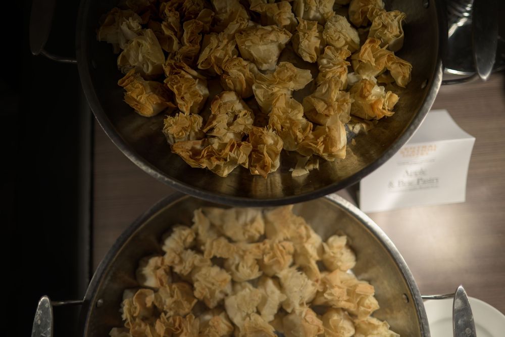 Cauliflower florets being cooked and browned in a cast iron skillet on a stovetop.