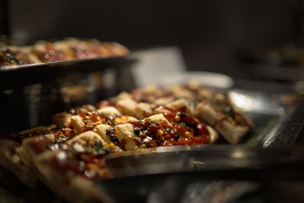 Close-up view of sizzling food cooking in a dark pan with dramatic lighting.