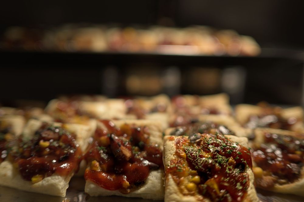 Close-up view of bruschetta appetizers topped with tomatoes, herbs, and balsamic glaze on a rustic wooden board.