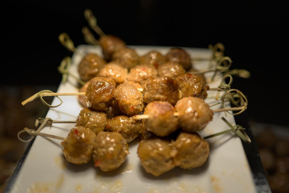 Golden brown meatballs arranged neatly on a white serving platter.