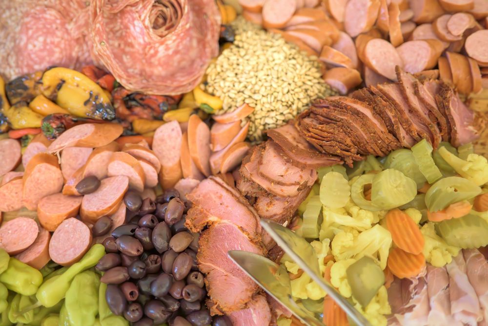 Overhead view of an elaborate charcuterie board with cured meats, cheese, grapes, and nuts.