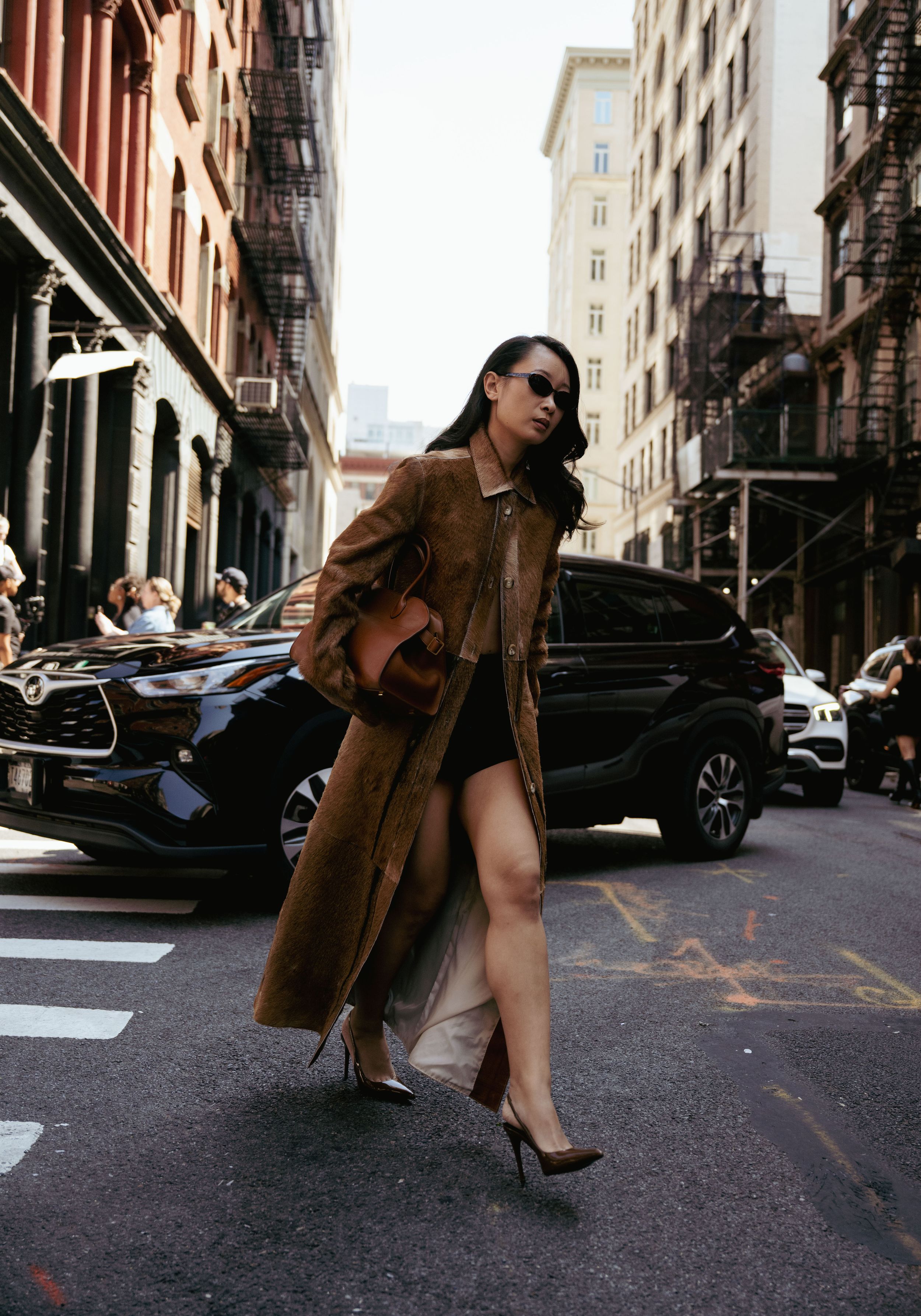 A series of fashion photos showing a brown coat and heels on a city street in New York.