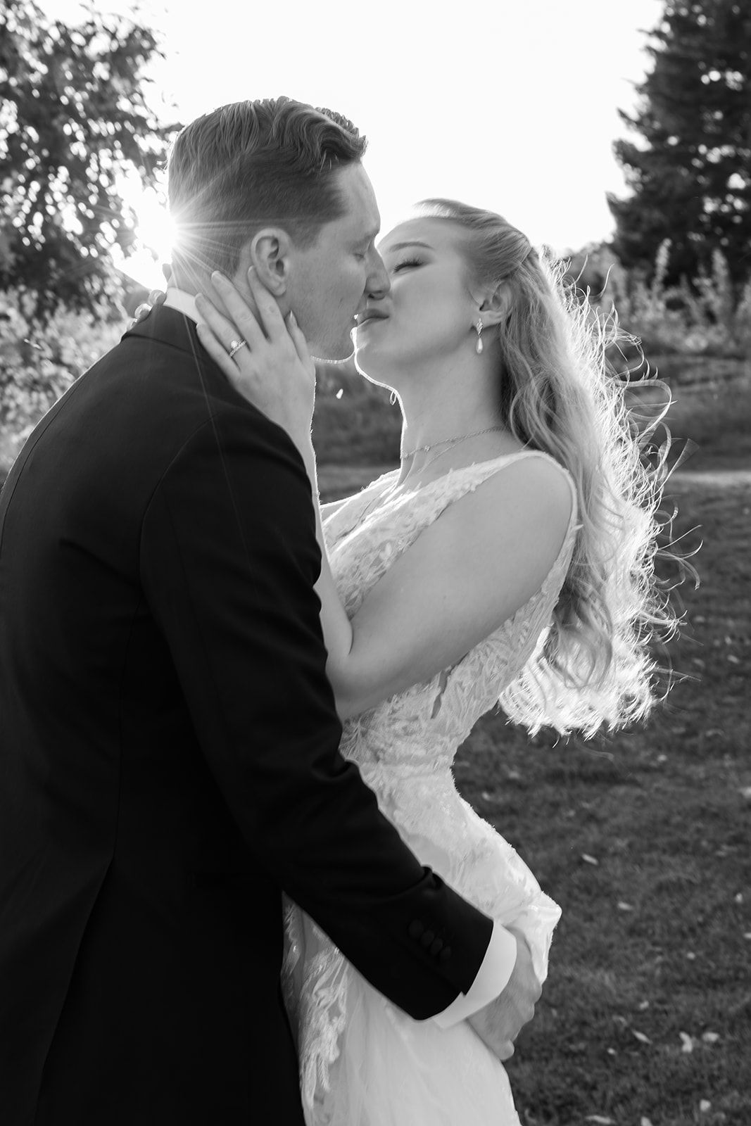 A romantic black and white photo series showing a couple embracing and kissing in an outdoor setting.