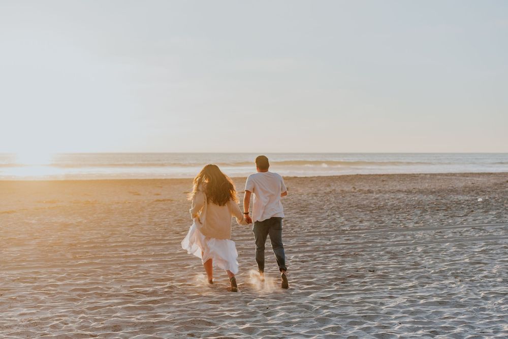 Blacks Beach couples photos with candid movement and dramatic coastal views, San Diego Engagement Photos