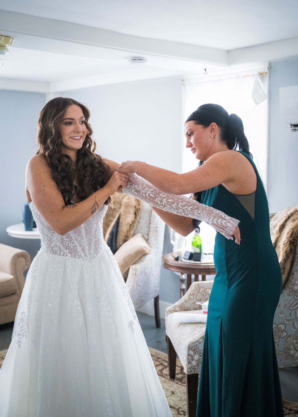 Wedding dress preparation scene with elegant white gown and emerald green bridesmaid dresses.