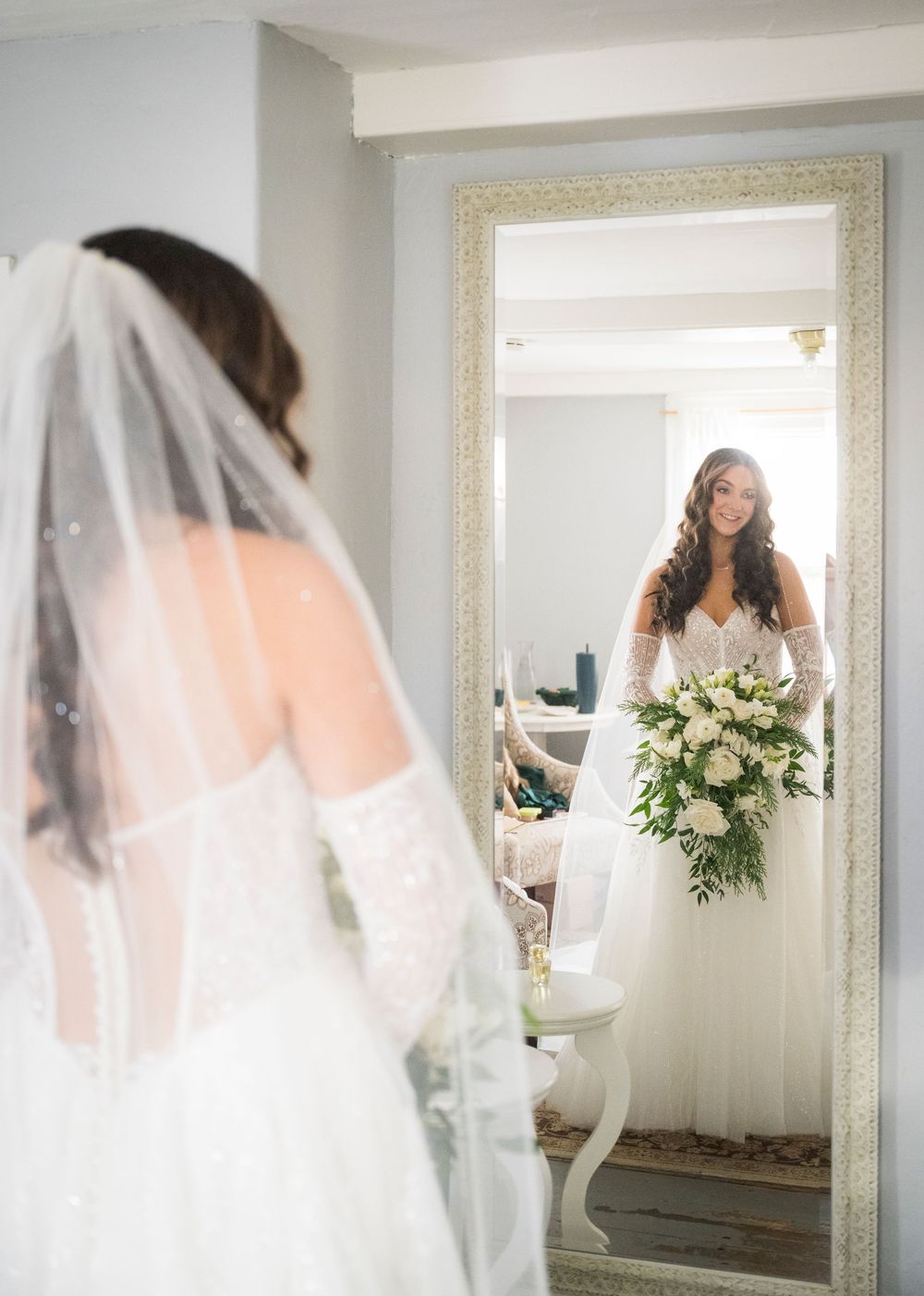 Bridal suite with ornate mirror reflections showing wedding dress preparations.