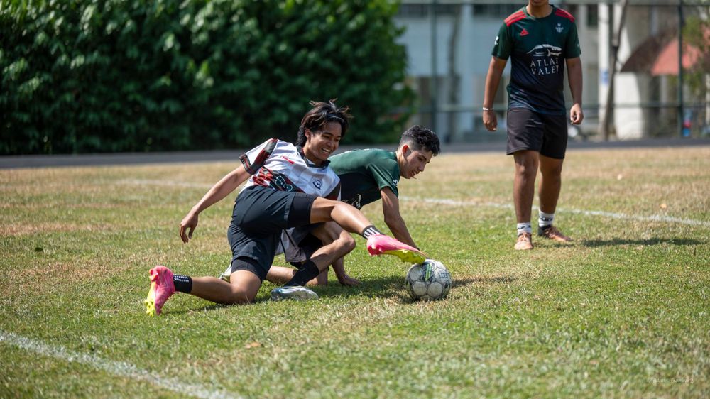 Soccer players battling for possession of the ball on a grassy field during a match.