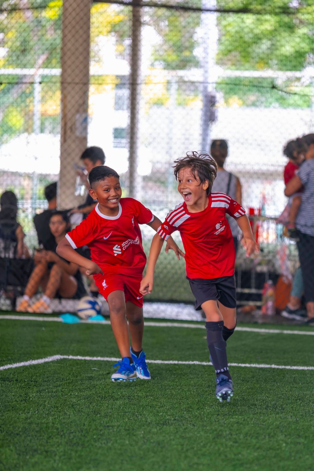 Young players in red uniforms running together during a youth soccer match.