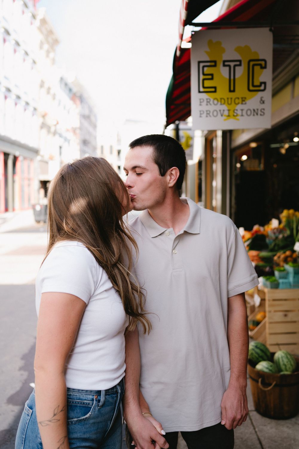 Intimate moment shared outside ETC Provisions storefront in an urban setting.