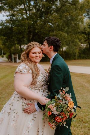 Romantic autumn wedding portraits with floral bouquet in outdoor setting.