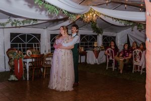 Wedding celebration in a tent venue with fabric draping and dance floor entertainment.
