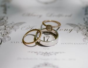 Wedding rings photographed on elegant white paper with decorative script.