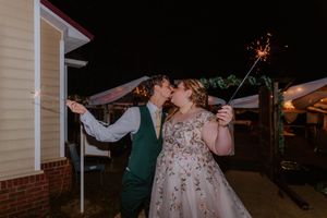Outdoor wedding reception at night with white tent and string lights.
