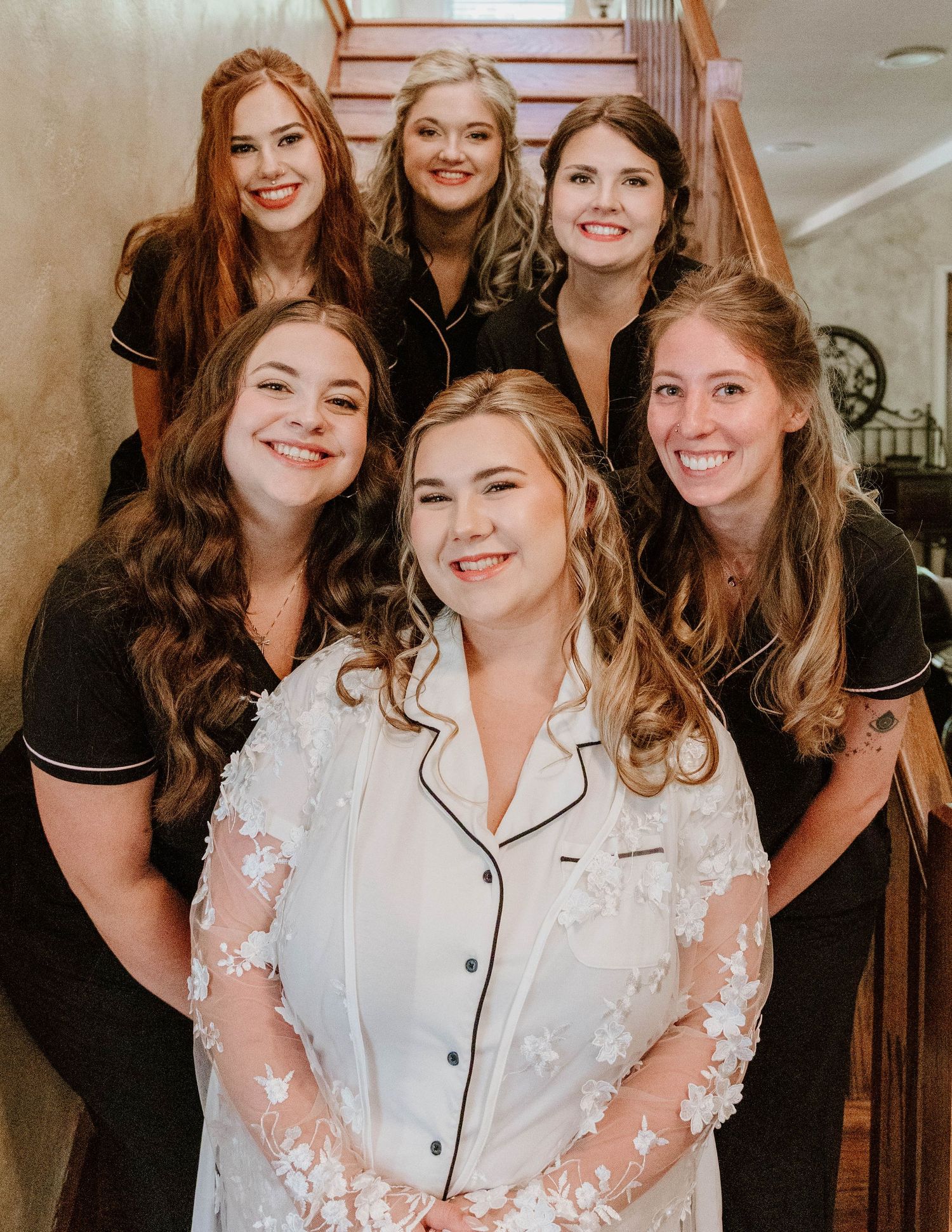 Wedding party members in matching robes share joyful moments during pre-ceremony preparations.