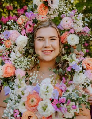 Colorful floral arrangement with pink, peach and white flowers including ranunculus and baby's breath.