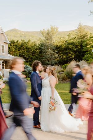 Motion blur captures wedding party dancing and celebrating outdoors.