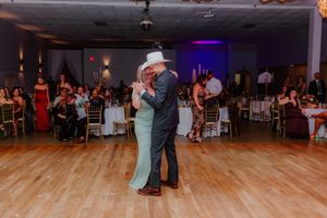 Wedding reception dance floor with couples dancing under ambient lighting.