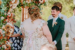 A romantic wedding moment captured with floral decorations and natural outdoor lighting.