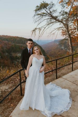 Romantic wedding photos on a mountain overlook with autumn foliage and scenic views.