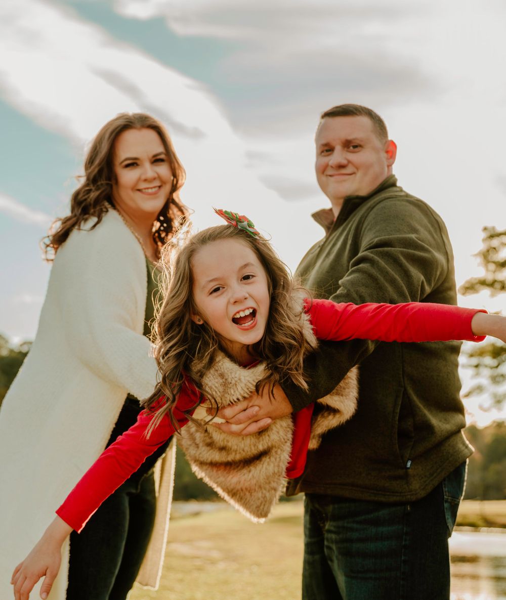 Playful group poses and laughs together in a sunlit field.