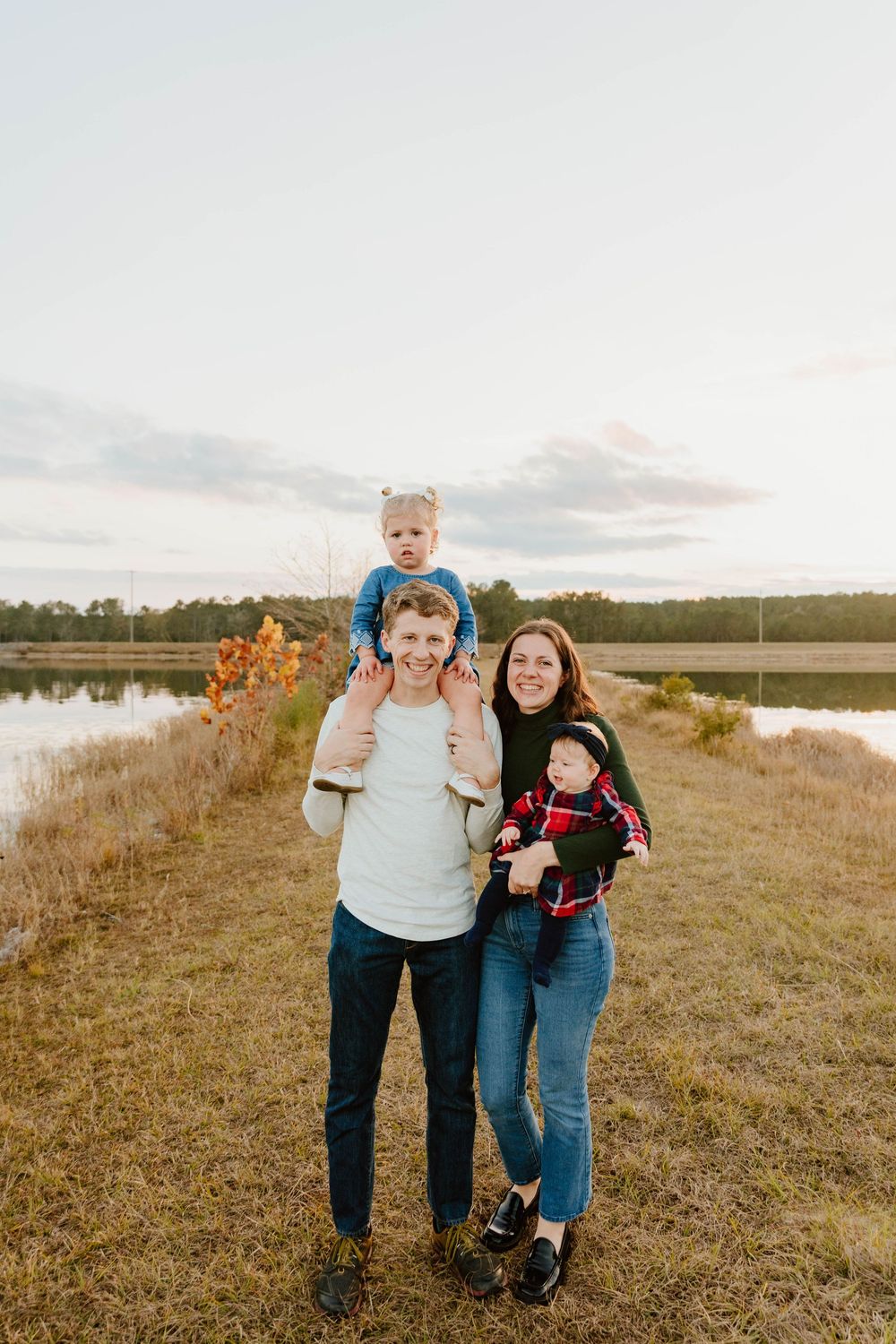 Happy family enjoying quality time together in an open field near a lake.