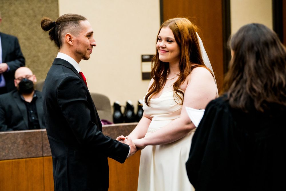 Wedding ceremony taking place in a formal room with modern lighting fixtures.