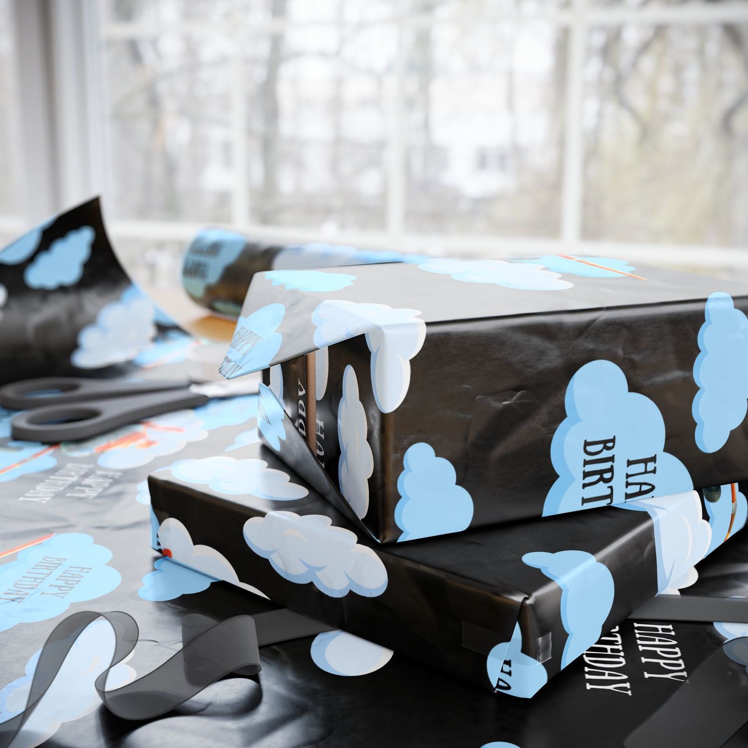 Multiple rolls of black wrapping paper with blue cloud and airplane pattern by window.
