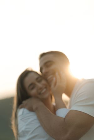 Intimate close-up portrait of a couple sharing a tender moment in golden sunset light.