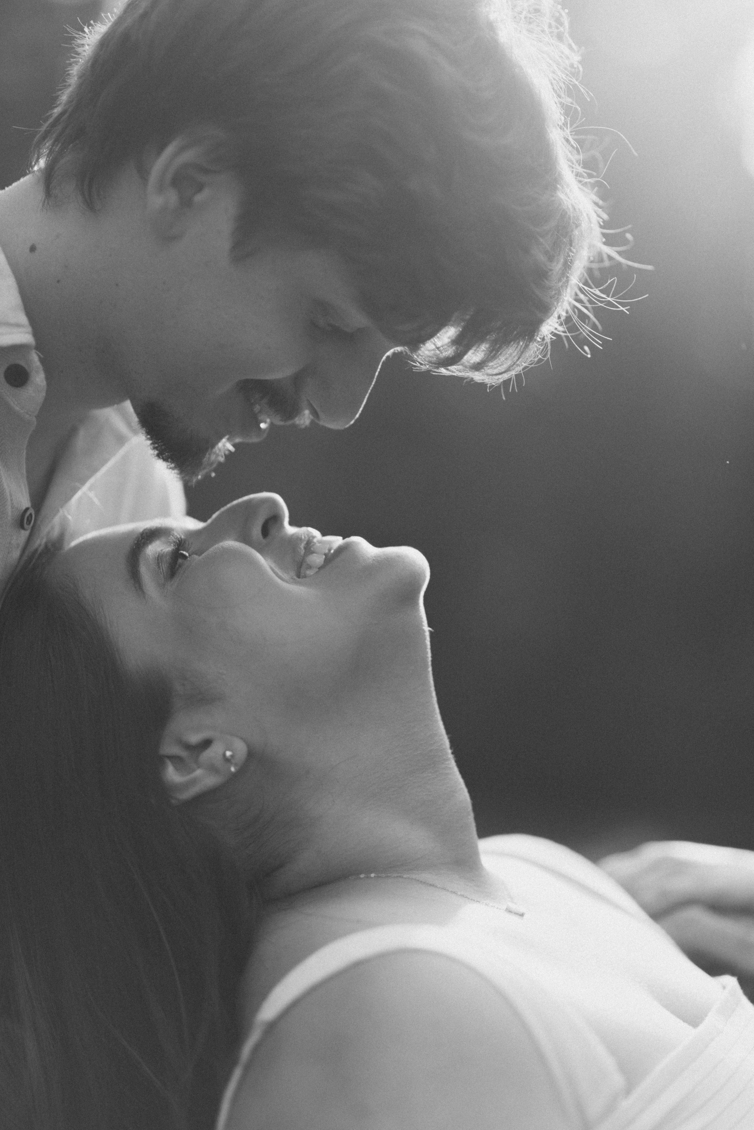 A romantic black and white portrait of a couple in an intimate moment.