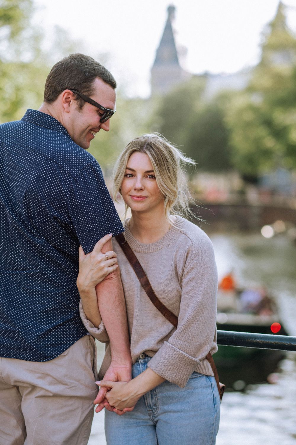 Candid moments of affection captured between a couple by the water.